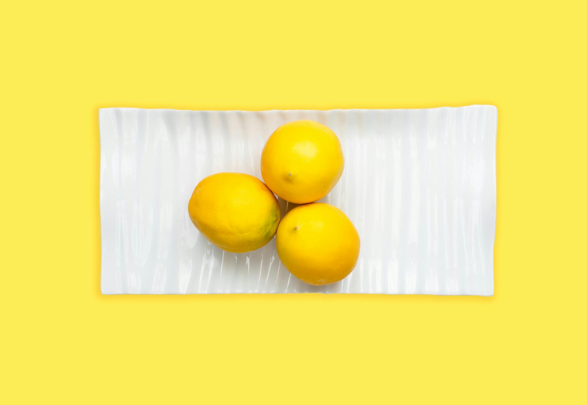 Fresh lemons on a white plate representing quick, efficient pleasure