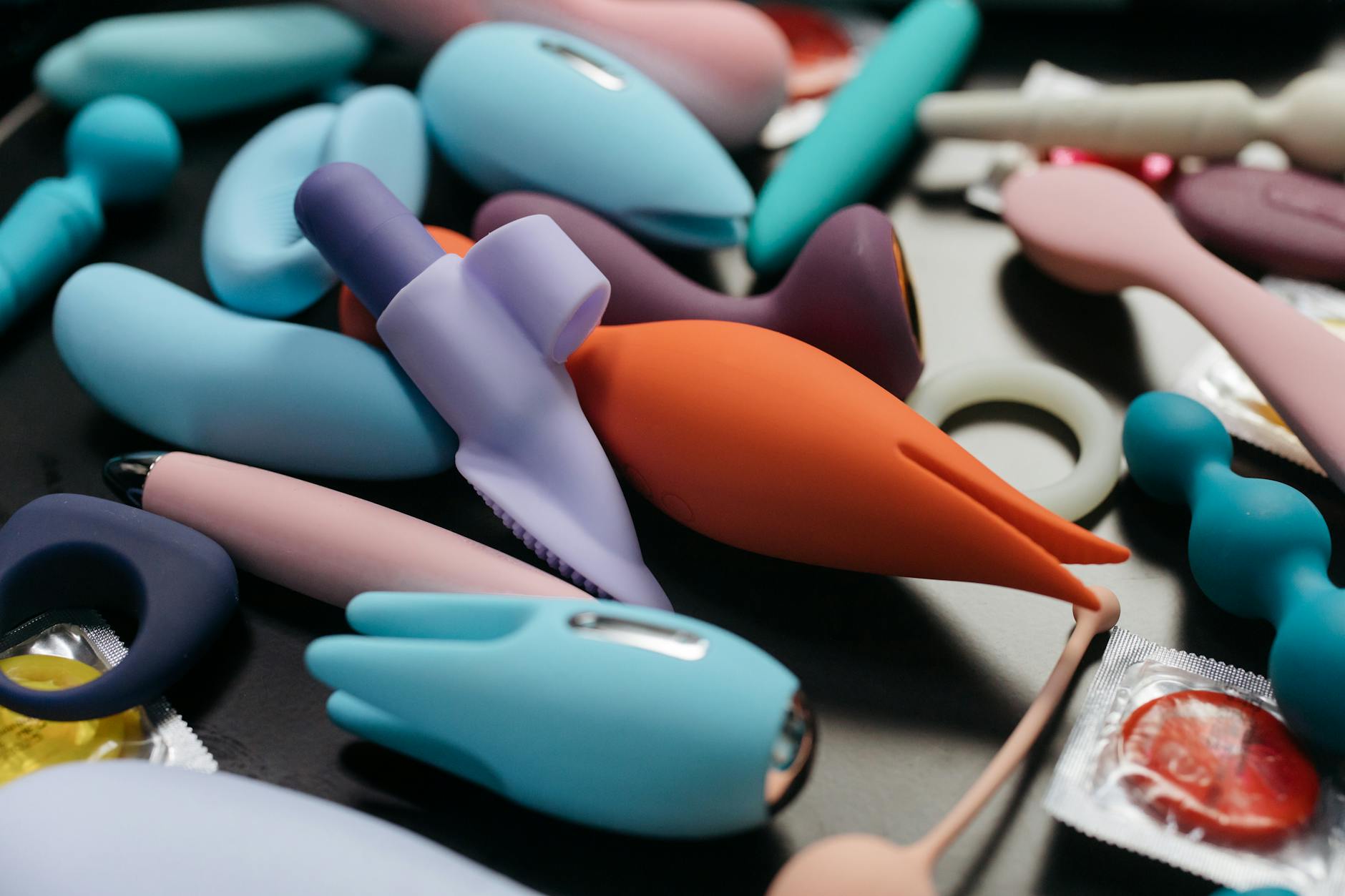 Woman holding blue and pink silicone vibrators in a contemplative moment of self-discovery