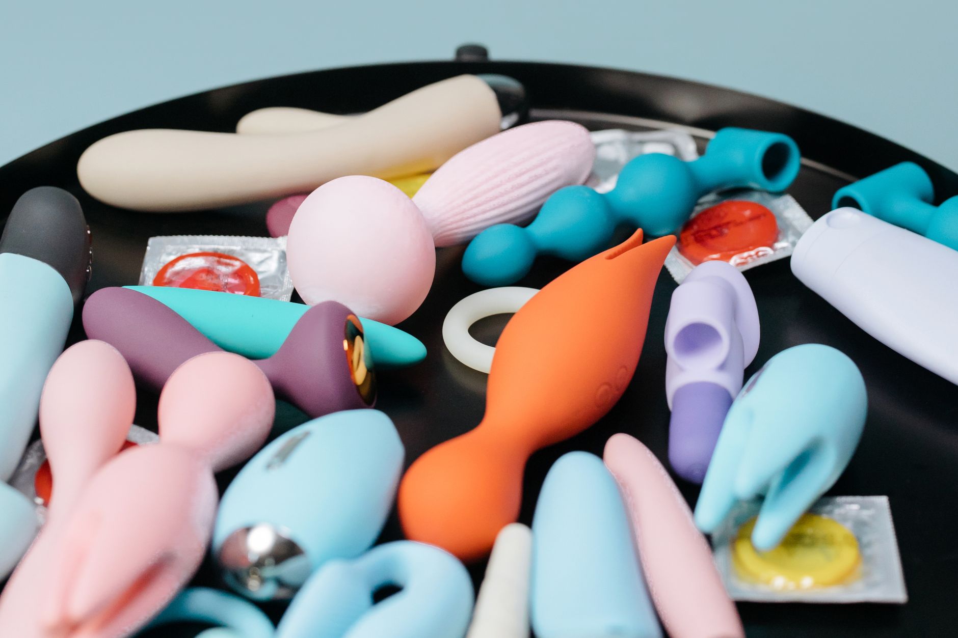 Colorful clitoral vibrators displayed on a bright yellow background