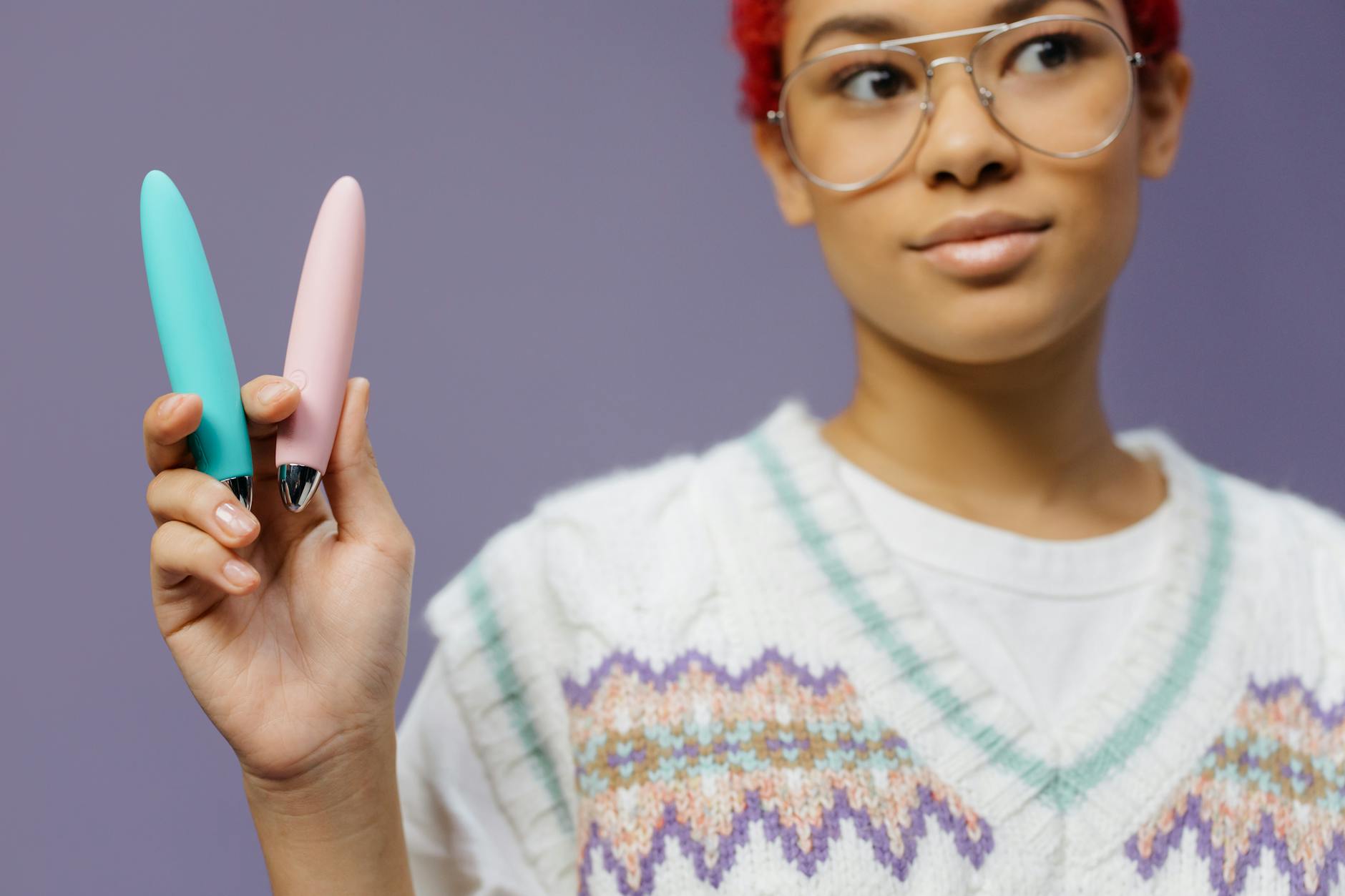 Woman holding colorful vibrators, representing pleasure recovery and intimate wellness