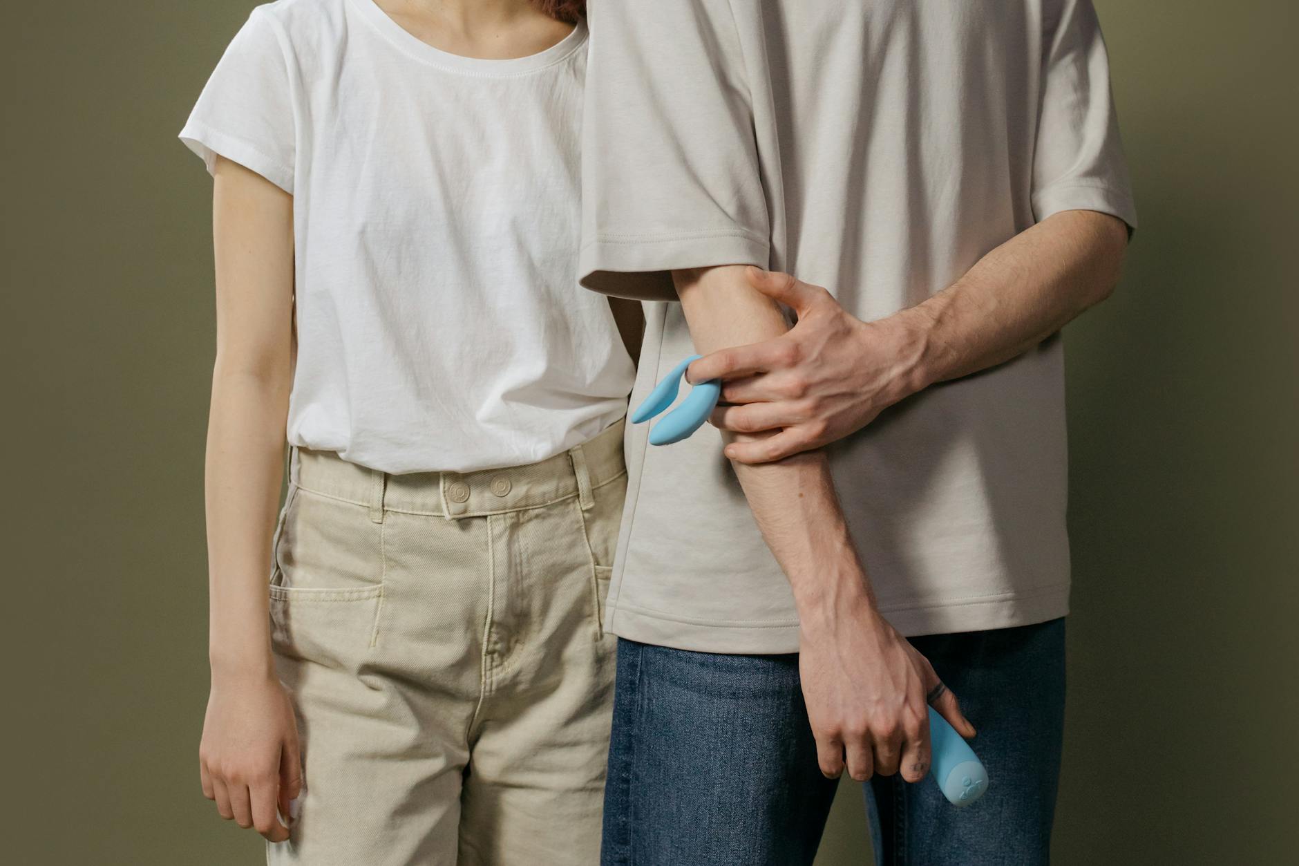 A young couple standing together indoors exploring intimate wellness with modern adult toys.