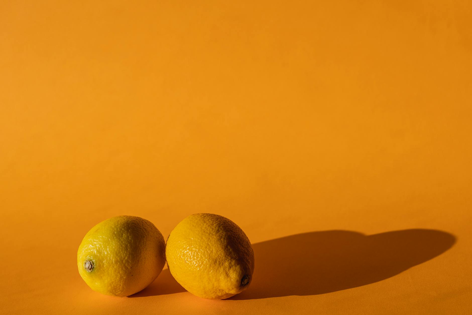 Bright yellow lemons on a soft yellow background, symbolizing fresh approaches to intimacy